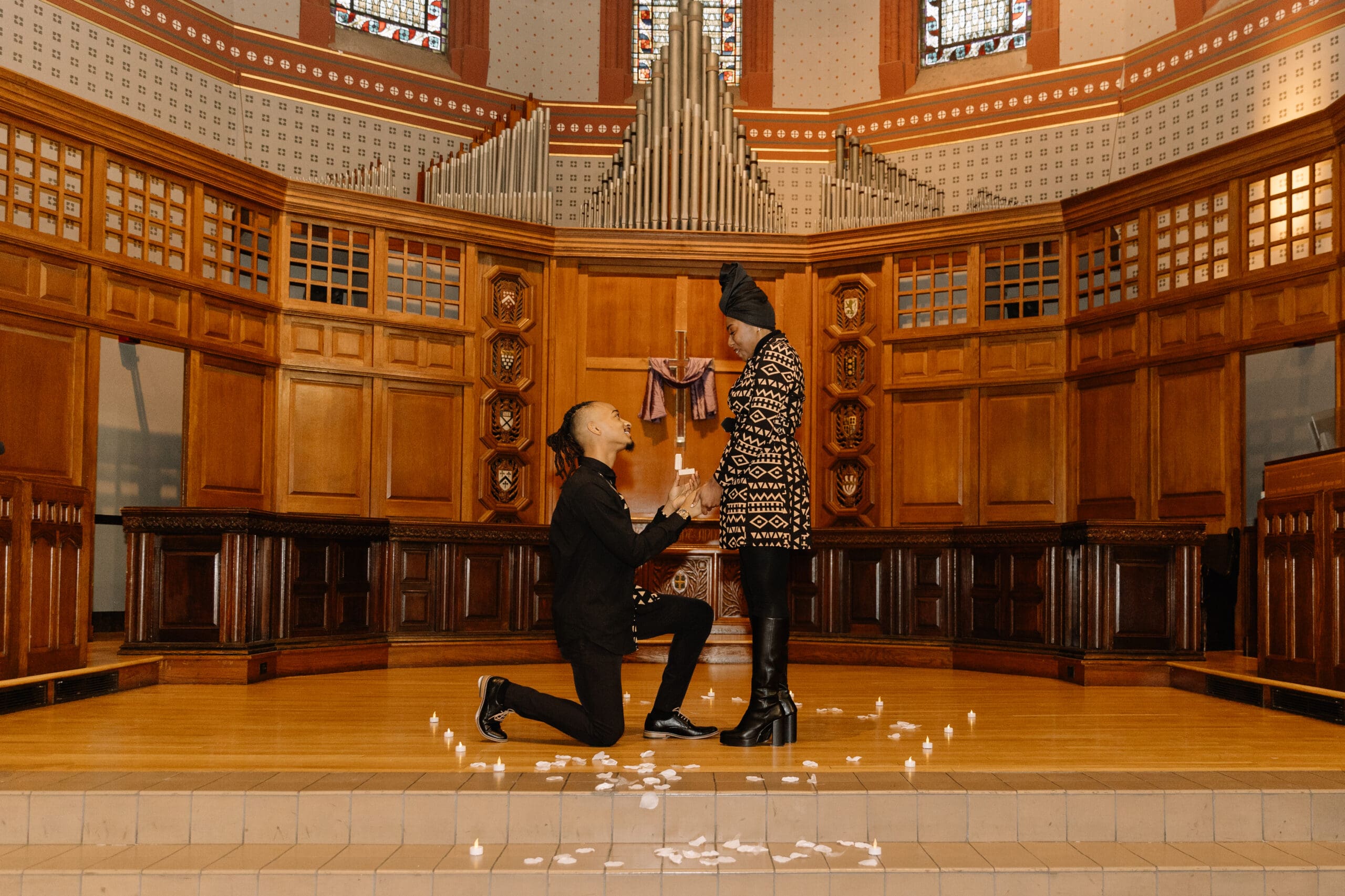 man down on one knee proposing at altar of battell chapel