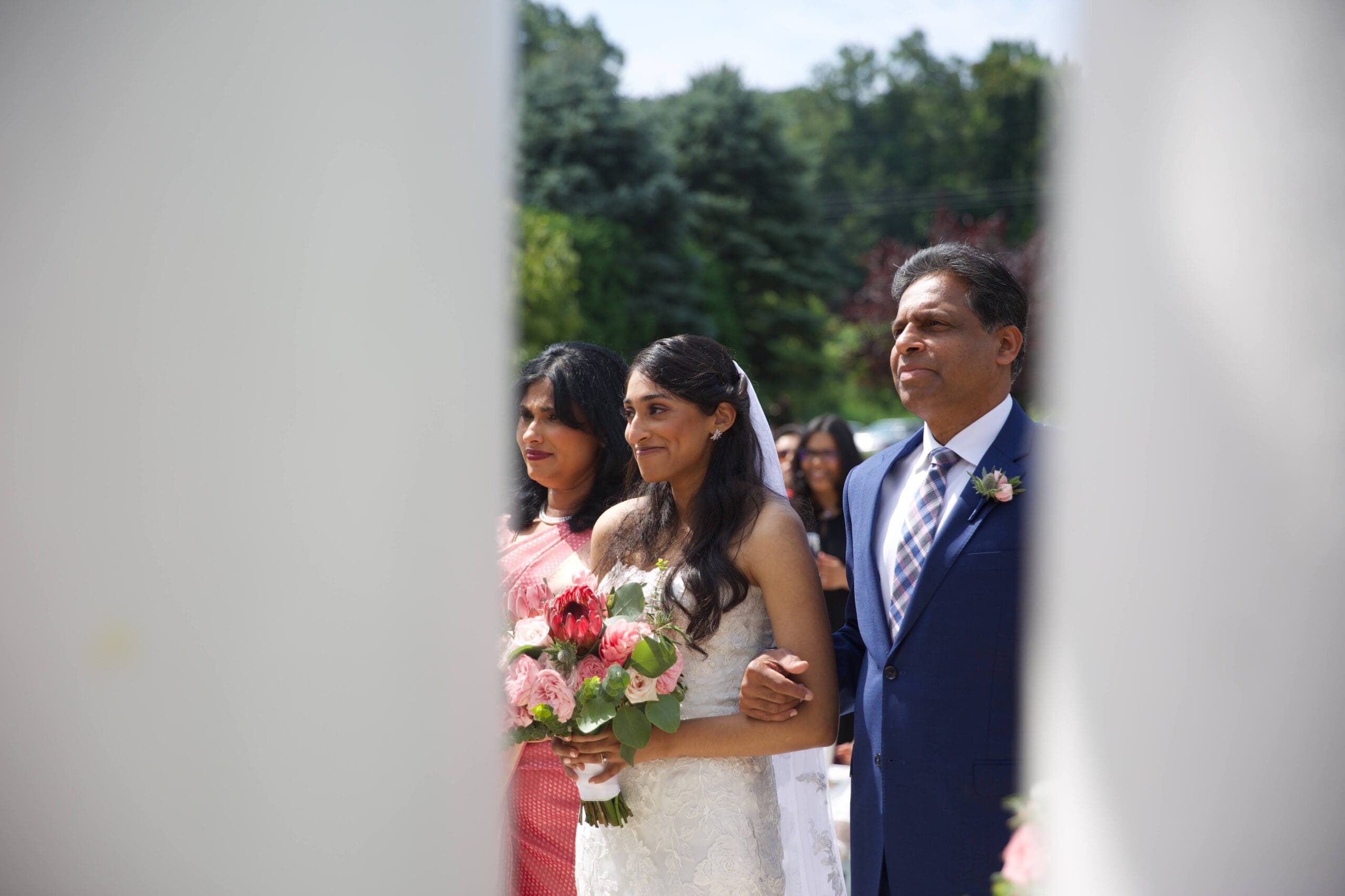 Bride being walked down the isle by mother and father on her wedding day